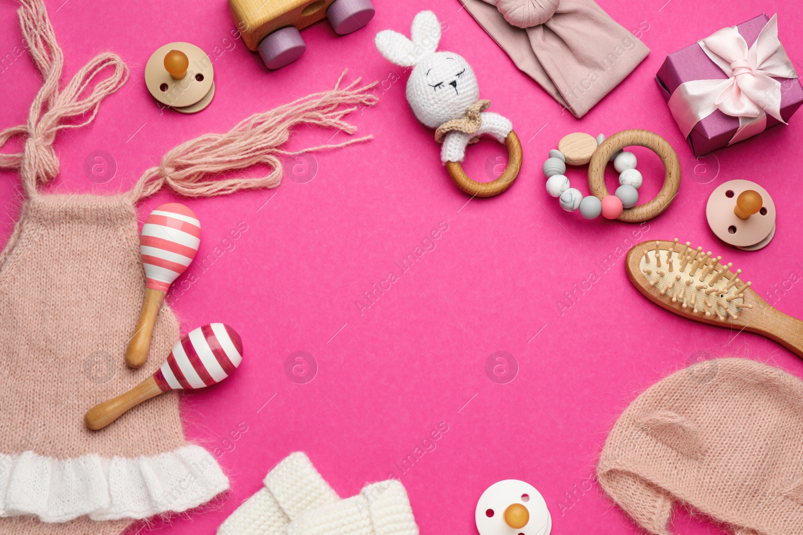 Photo of Frame of baby clothes and accessories on pink background, flat lay. Space for text