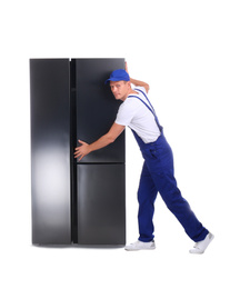 Professional worker carrying refrigerator on white background