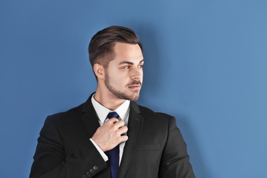 Portrait of young man with beautiful hair on color background