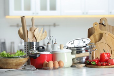 Photo of Set of cooking utensils and products on white table against blurred background