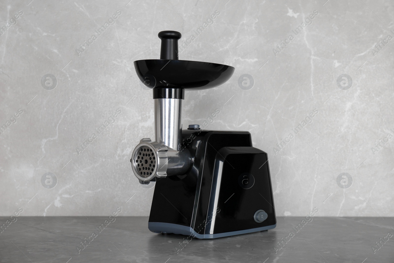 Photo of Modern electric meat grinder on grey table