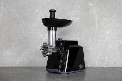 Photo of Modern electric meat grinder on grey table