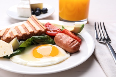 Photo of Delicious breakfast with fried egg served on white table, closeup