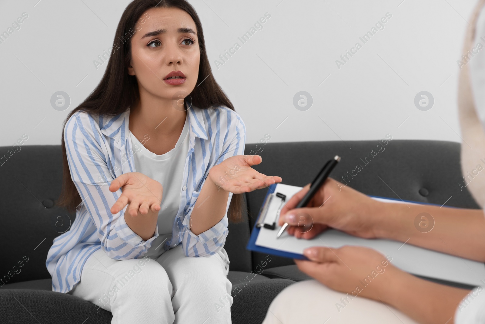 Photo of Professional psychologist working with young woman in office, closeup