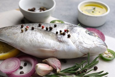 Photo of Fresh dorado fish and ingredients on white table, closeup