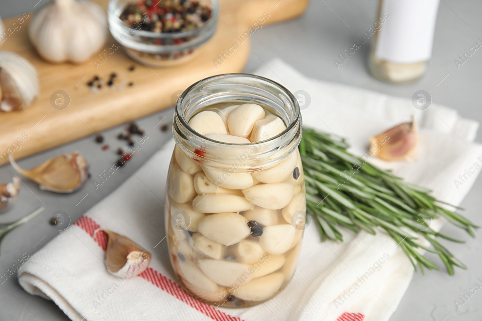 Photo of Composition with jar of pickled garlic on grey table