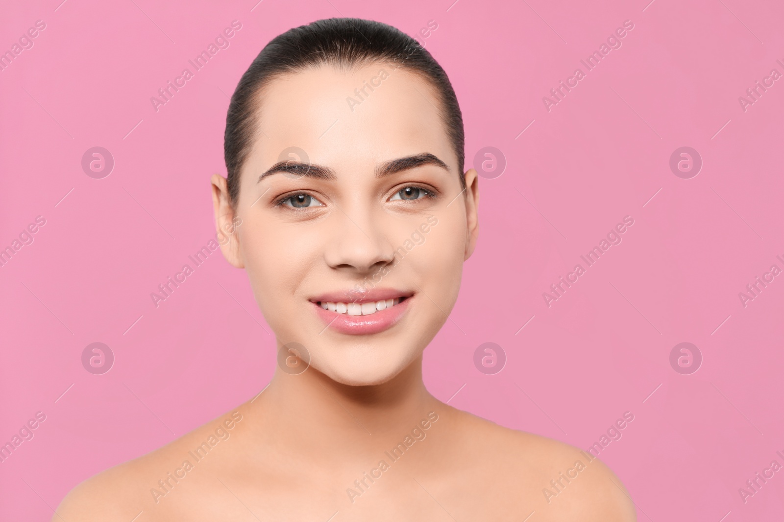 Photo of Portrait of young woman with beautiful face and natural makeup on color background