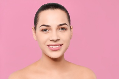 Portrait of young woman with beautiful face and natural makeup on color background