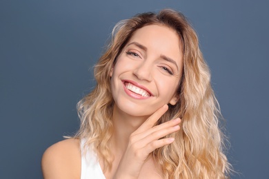 Young woman with beautiful smile on color background. Teeth whitening