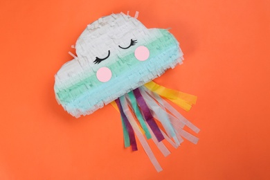 Photo of Bright cloud pinata on orange background, top view