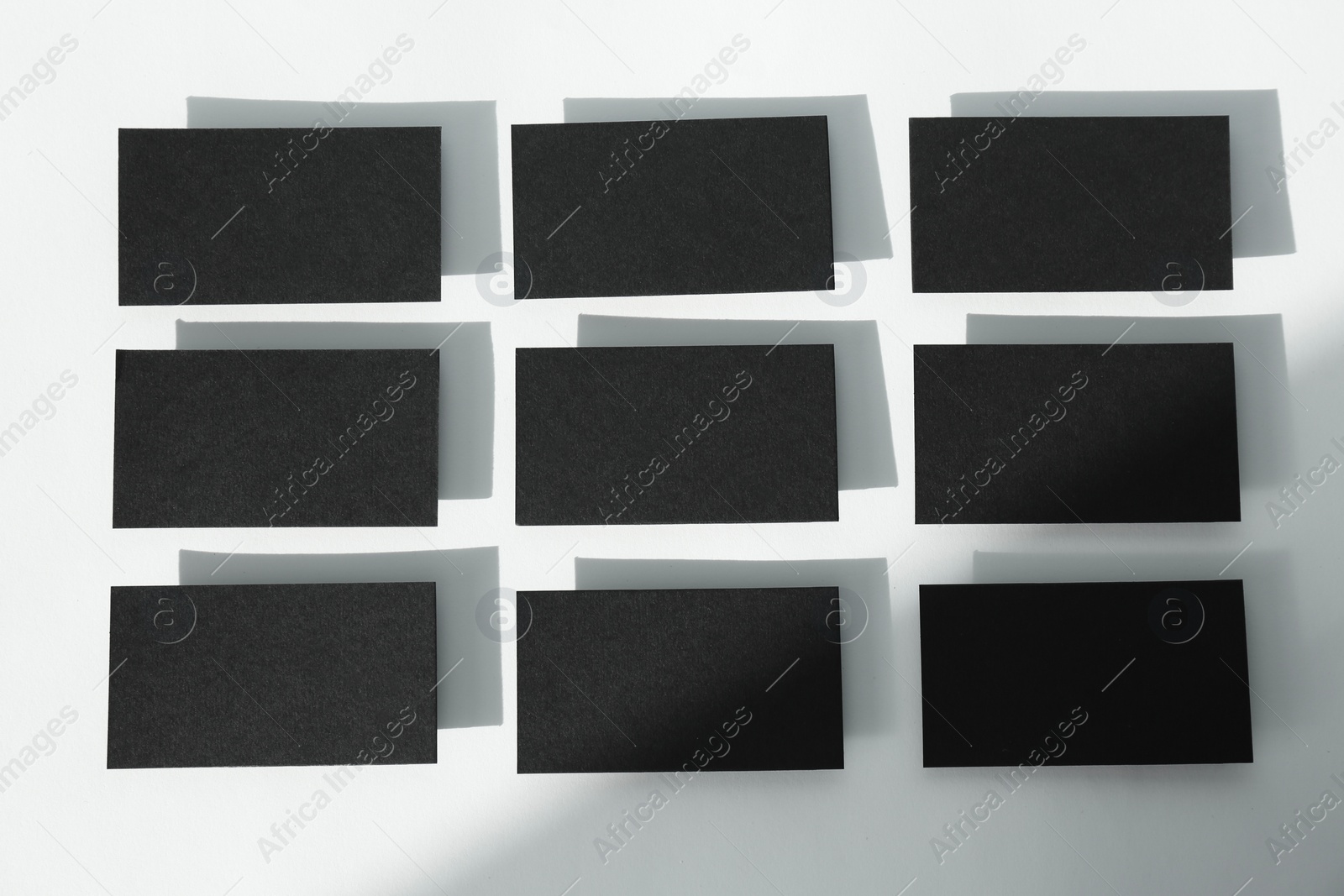 Photo of Blank black business cards on light background, flat lay. Mockup for design