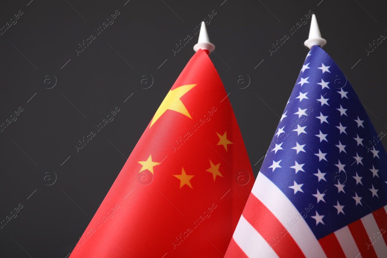 Photo of Closeup view of USA and China flags on dark background. International relations