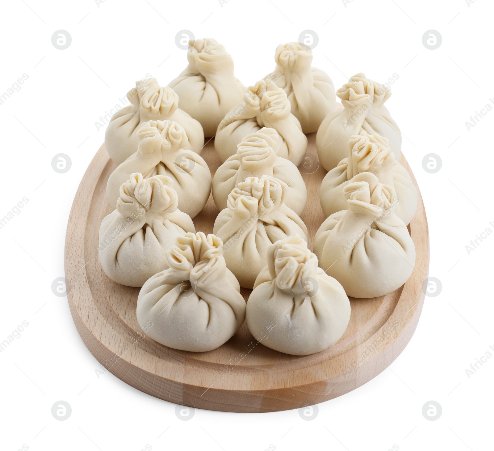 Photo of Wooden board with uncooked khinkali (dumplings) isolated on white. Georgian cuisine