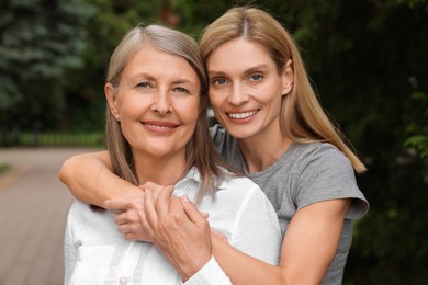 Happy mature mother and her daughter outdoors