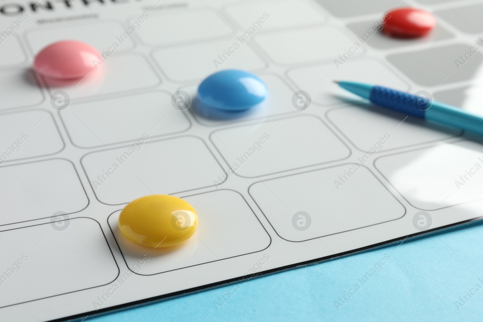 Photo of Timetable. Planner, pen and drawing pins on light blue background, closeup