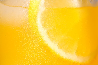 Glass of refreshing drink with sliced lemon on light background, closeup