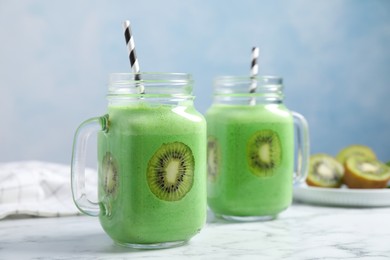 Photo of Tasty fresh kiwi smoothie on white marble table, space for text