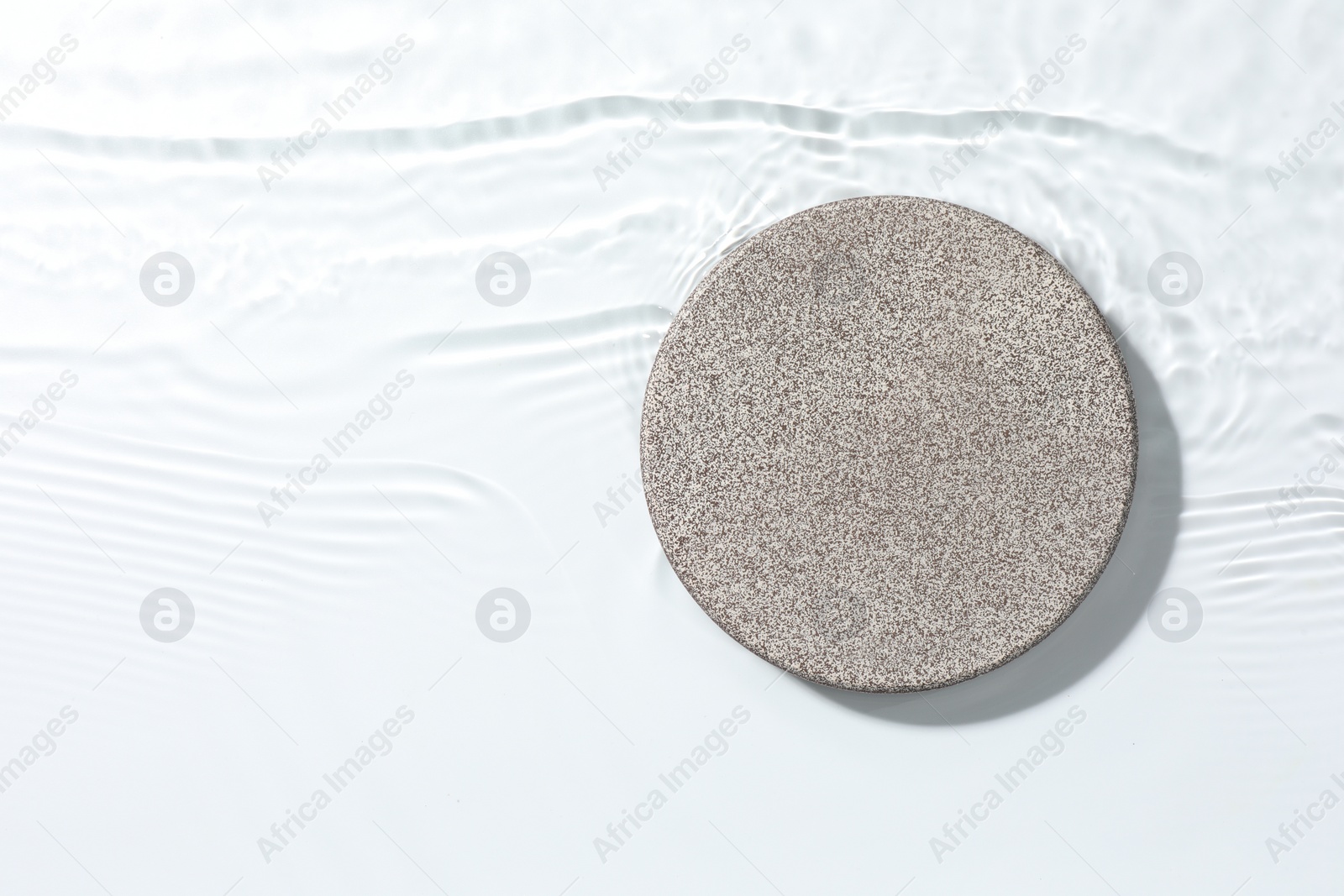 Photo of Presentation of product. Stone podium in water on white background, top view. Space for text