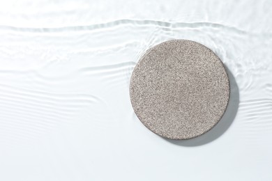 Photo of Presentation of product. Stone podium in water on white background, top view. Space for text