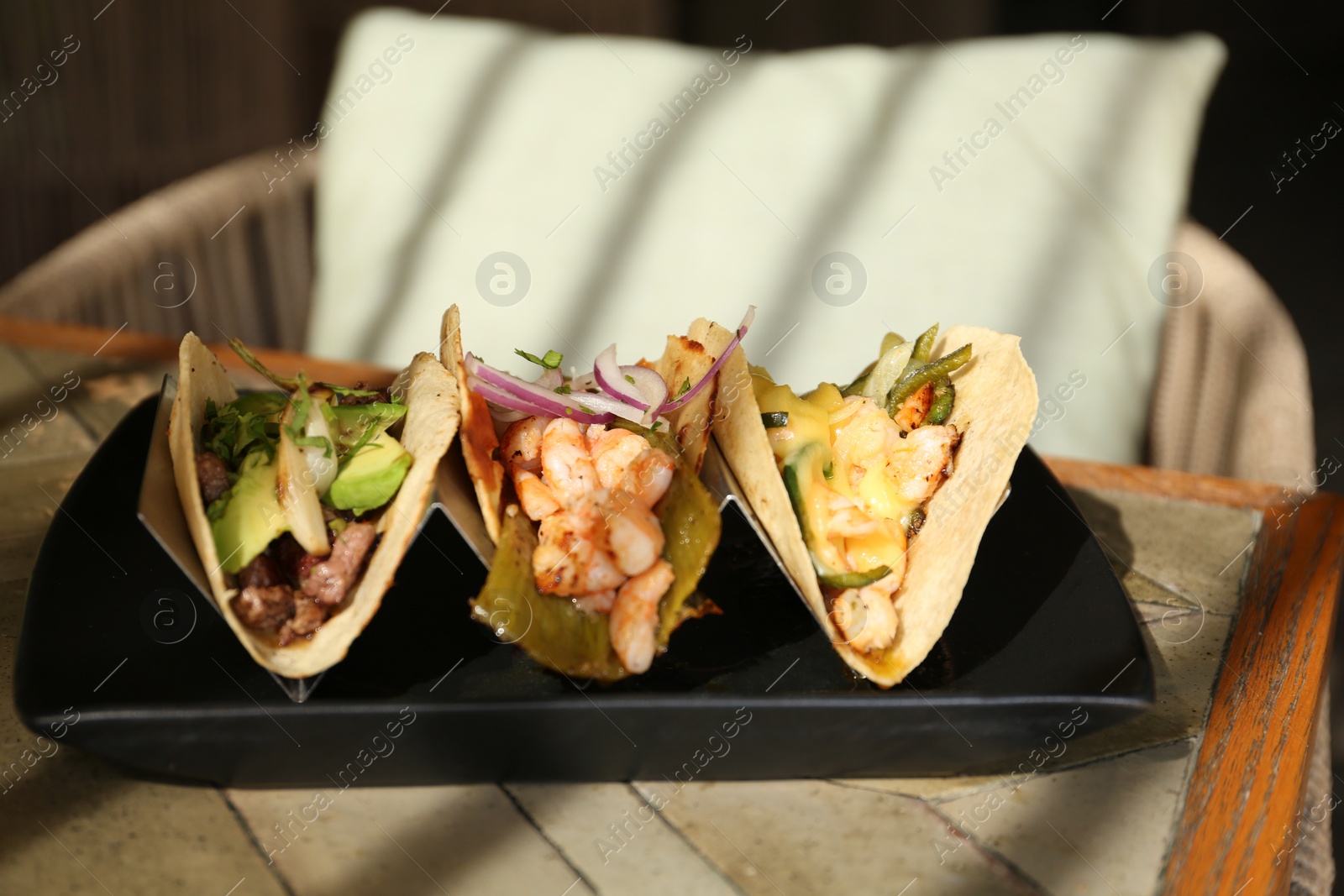 Photo of Delicious tacos with shrimps and vegetables on table