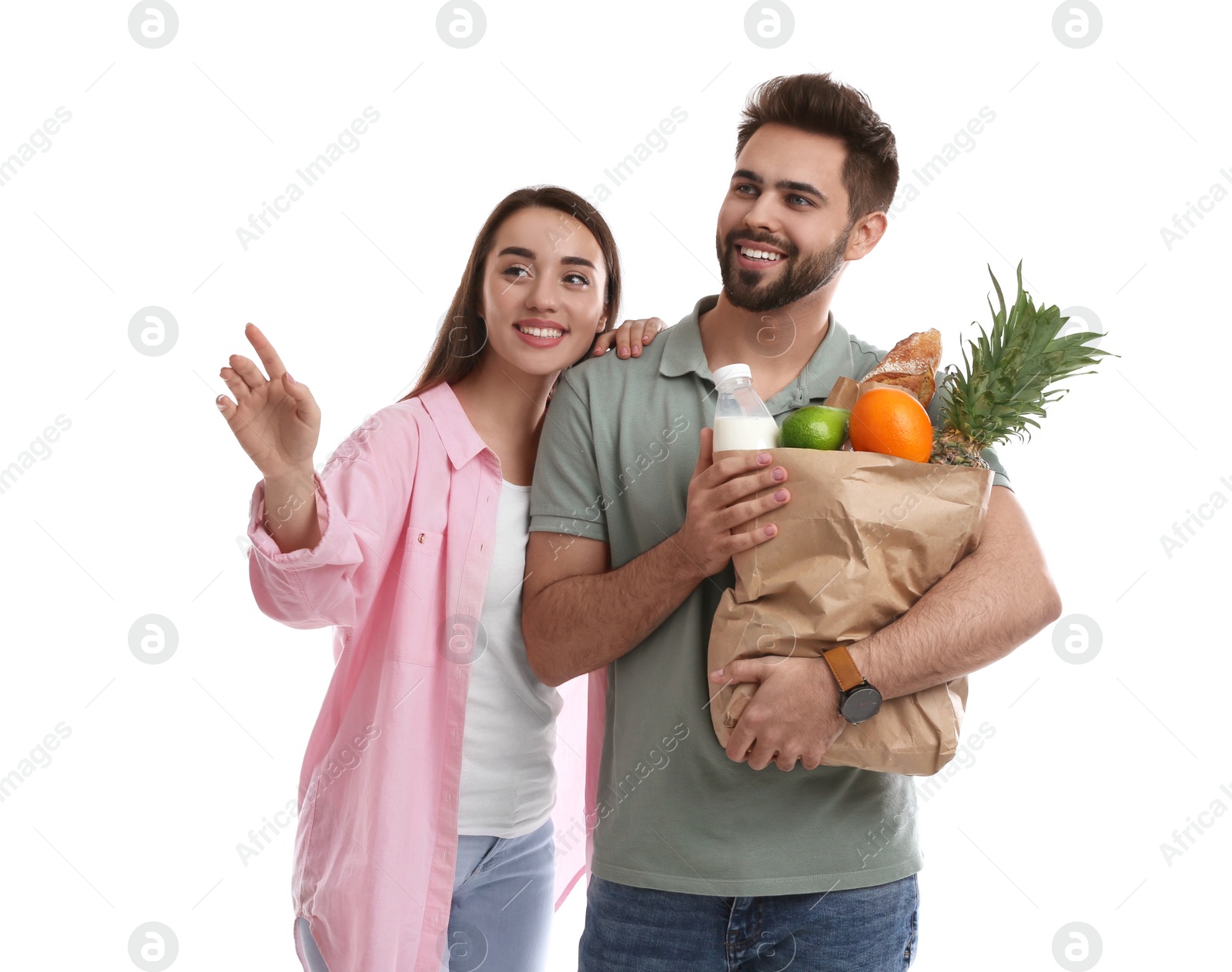 Photo of Young couple with groceries on white background