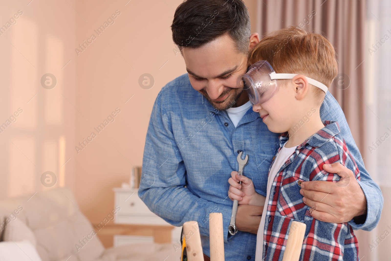 Photo of Father and son repairing stool at home, space for text