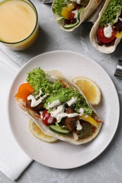 Photo of Delicious fresh vegan tacos served on light grey marble table, flat lay