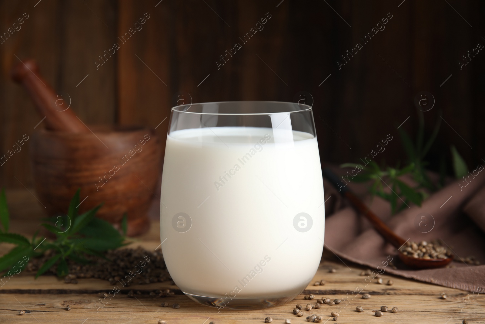 Photo of Glass of fresh hemp milk on wooden table