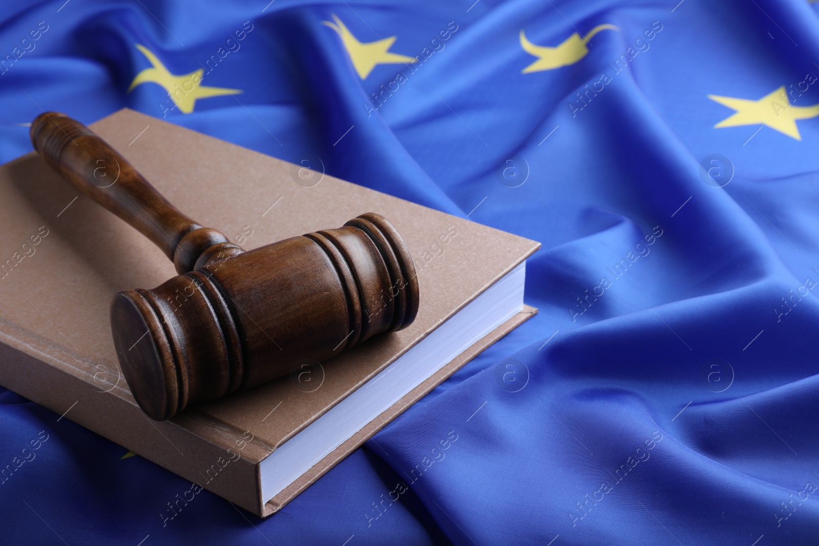 Photo of Wooden judge's gavel and book on flag of European Union, space for text