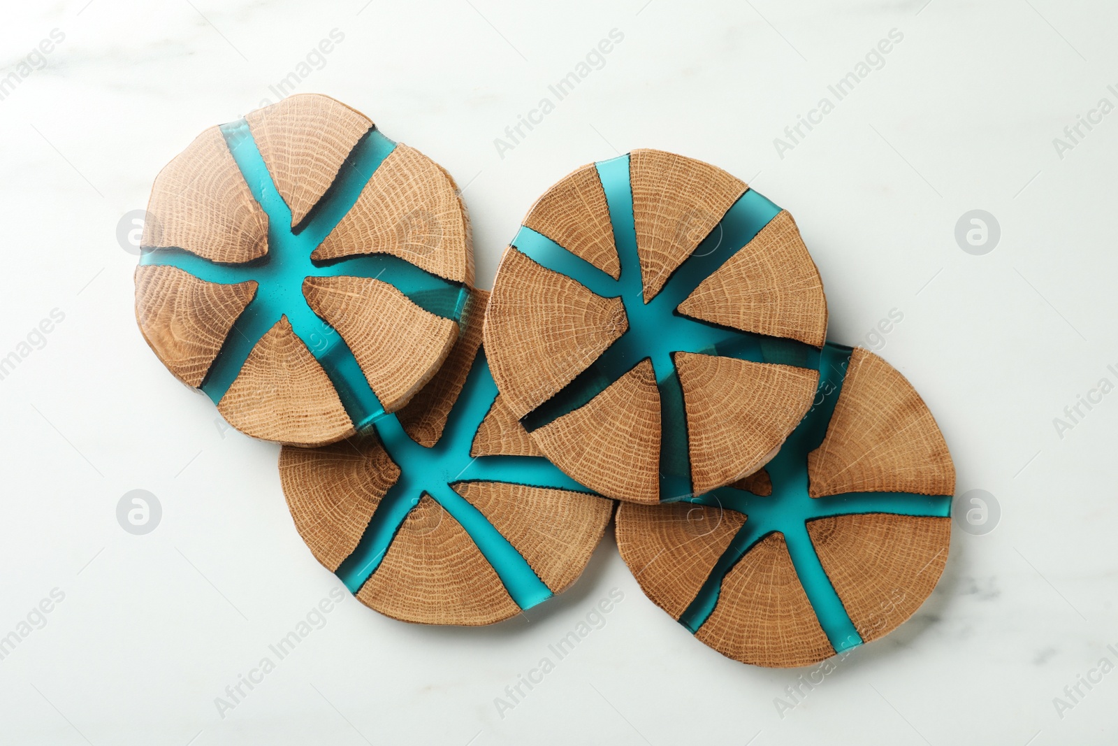 Photo of Stylish wooden cup coasters on white marble table, flat lay