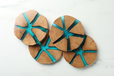 Stylish wooden cup coasters on white marble table, flat lay