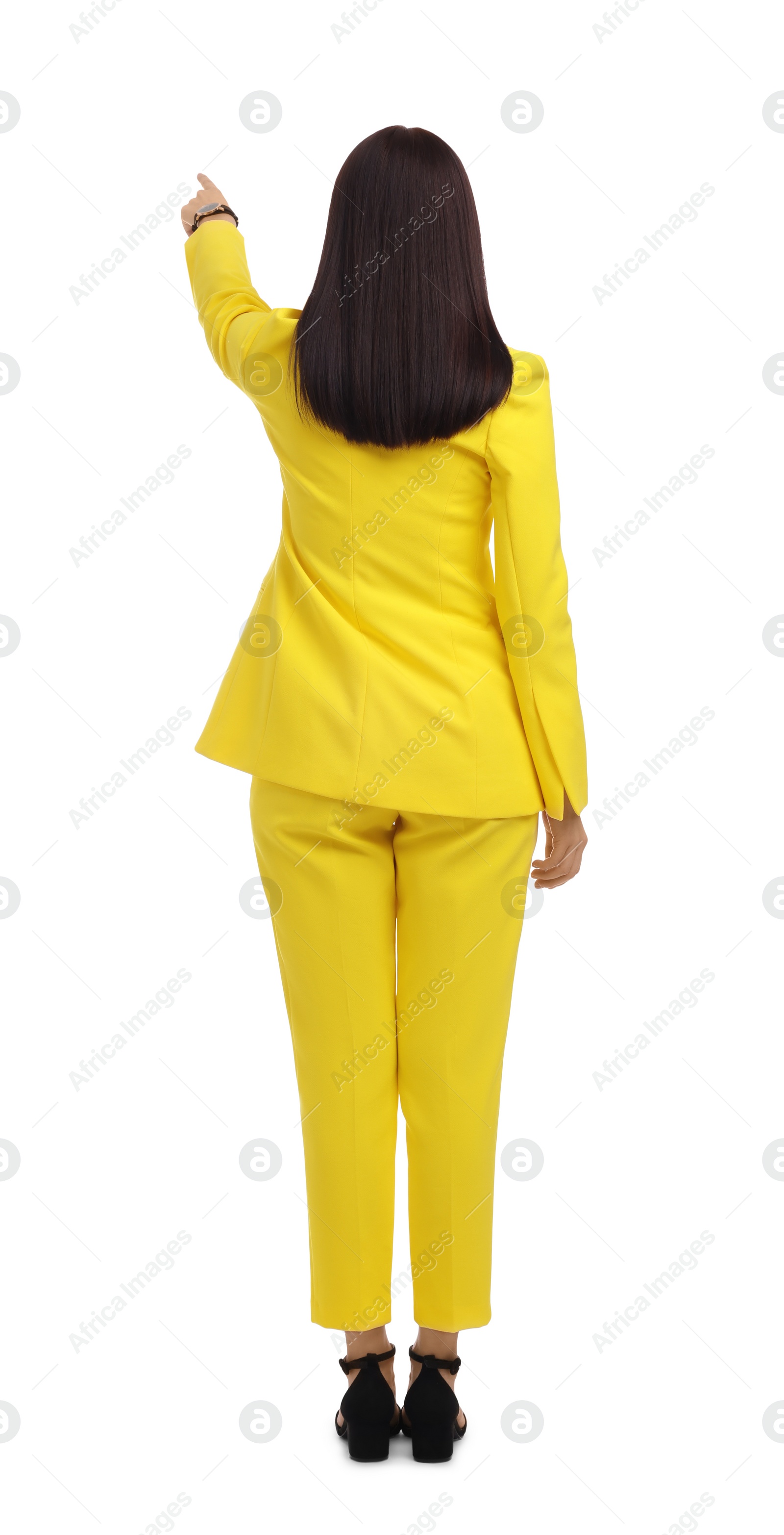 Photo of Businesswoman in yellow suit pointing at something on white background, back view