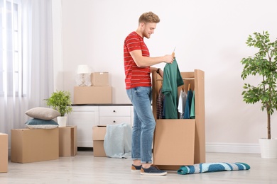 Photo of Young man near wardrobe box at home