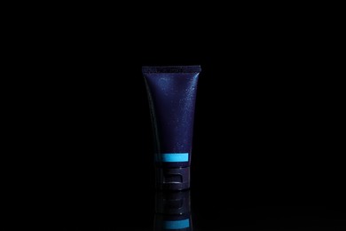 Tube of men's facial cream on black background