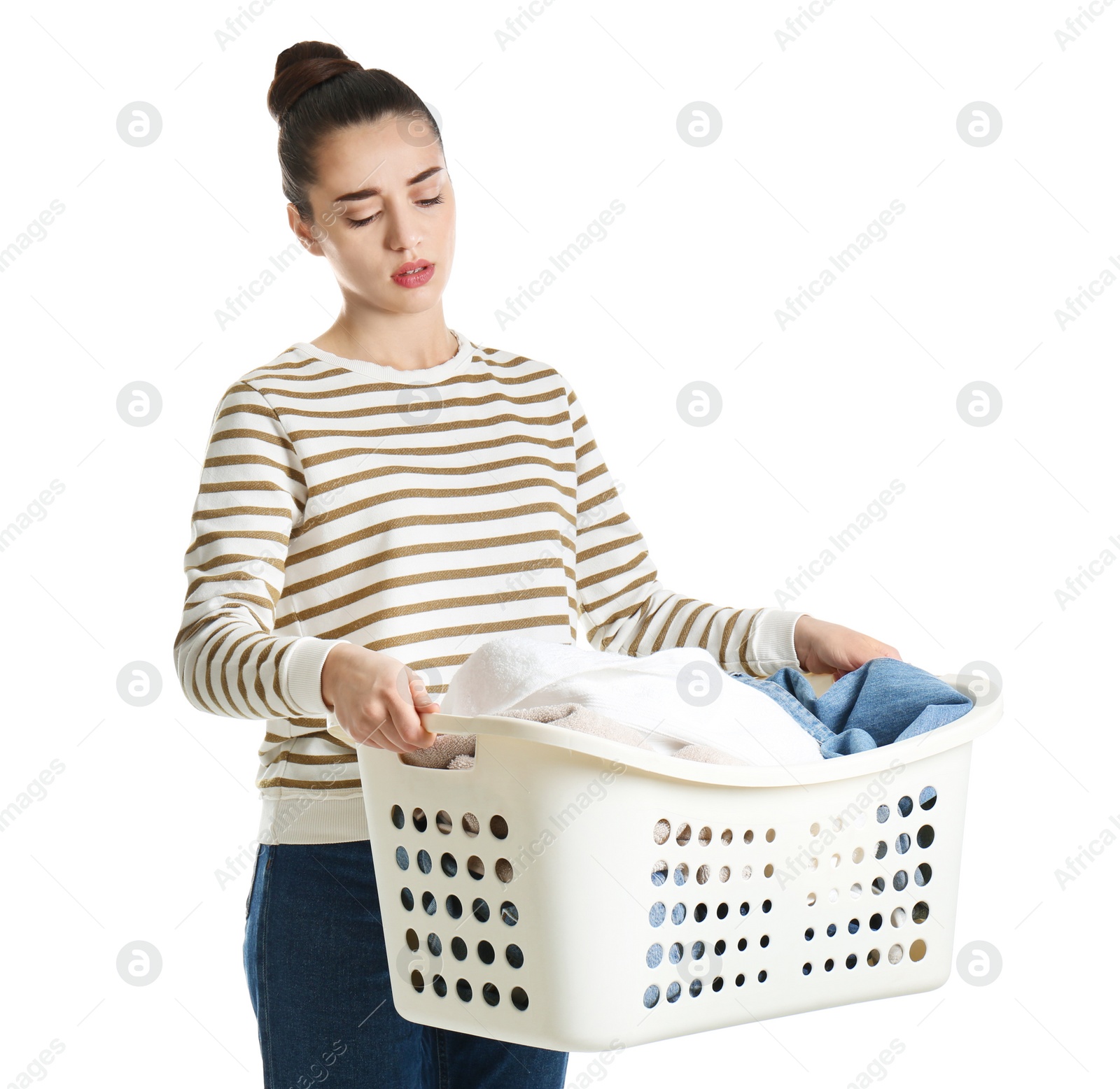 Photo of Displeased young woman holding basket with laundry on white background