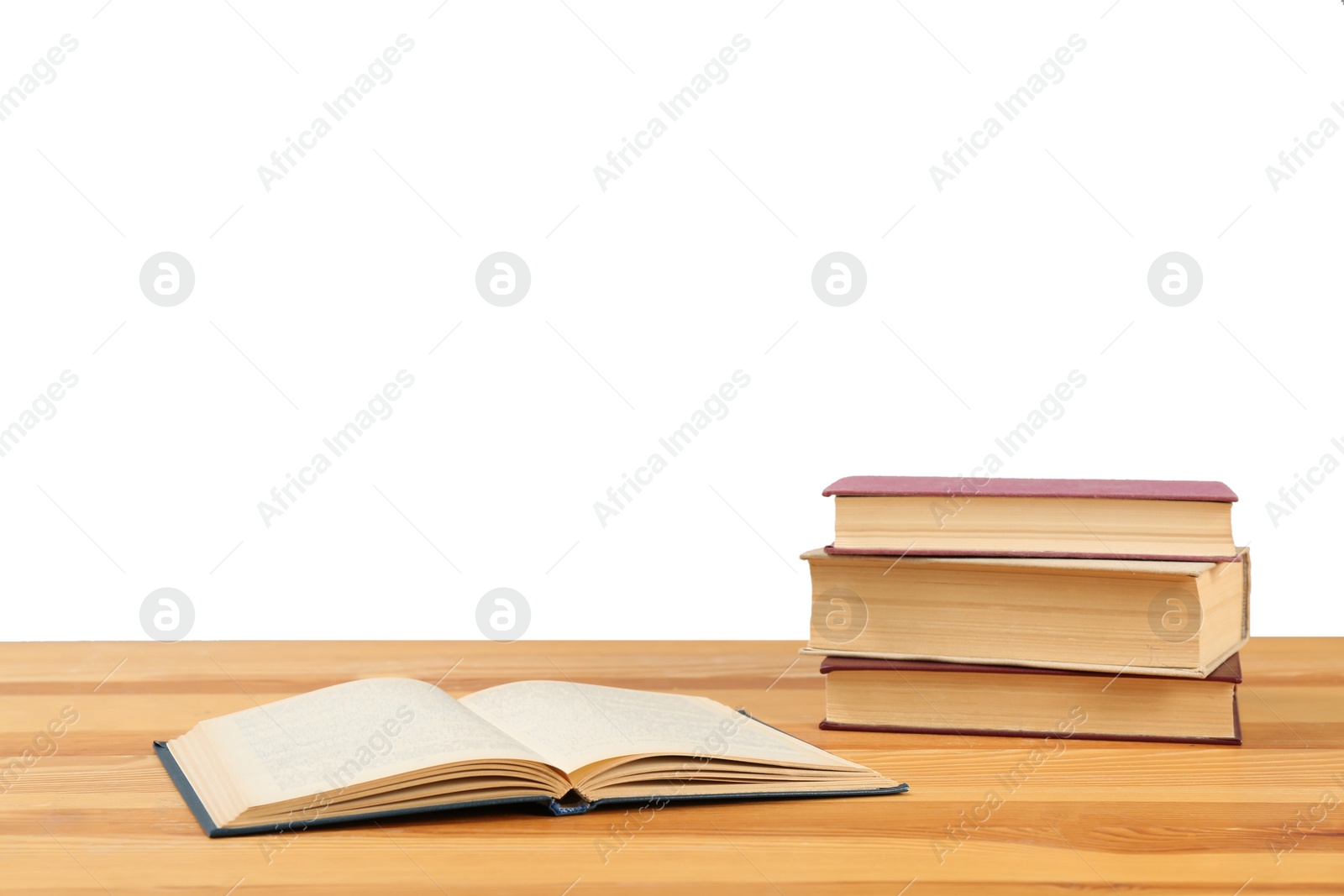 Photo of Many books on wooden table against white background. Library material