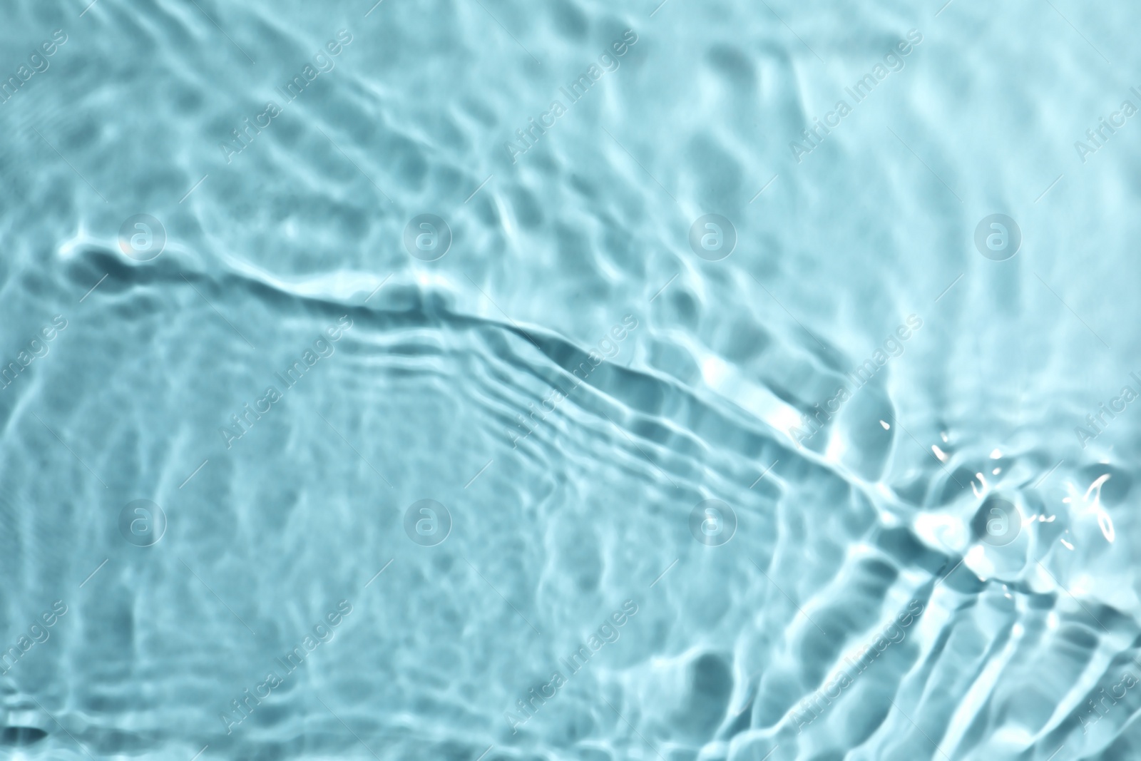 Photo of Closeup view of water with rippled surface on turquoise background