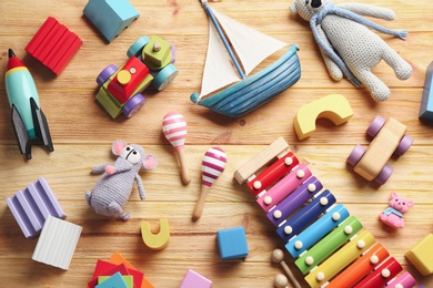 Photo of Different toys on wooden background, flat lay