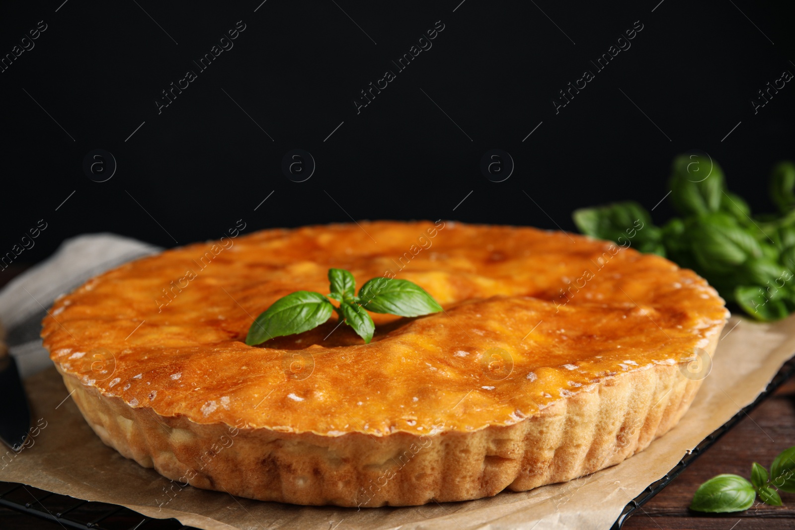 Photo of Delicious pie with meat and basil on wooden table