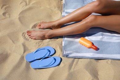 Photo of Woman resting and slippers on sandy beach, closeup