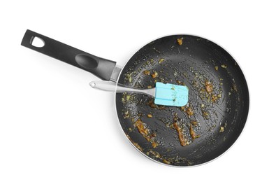 Photo of Dirty frying pan and spatula on white background, top view