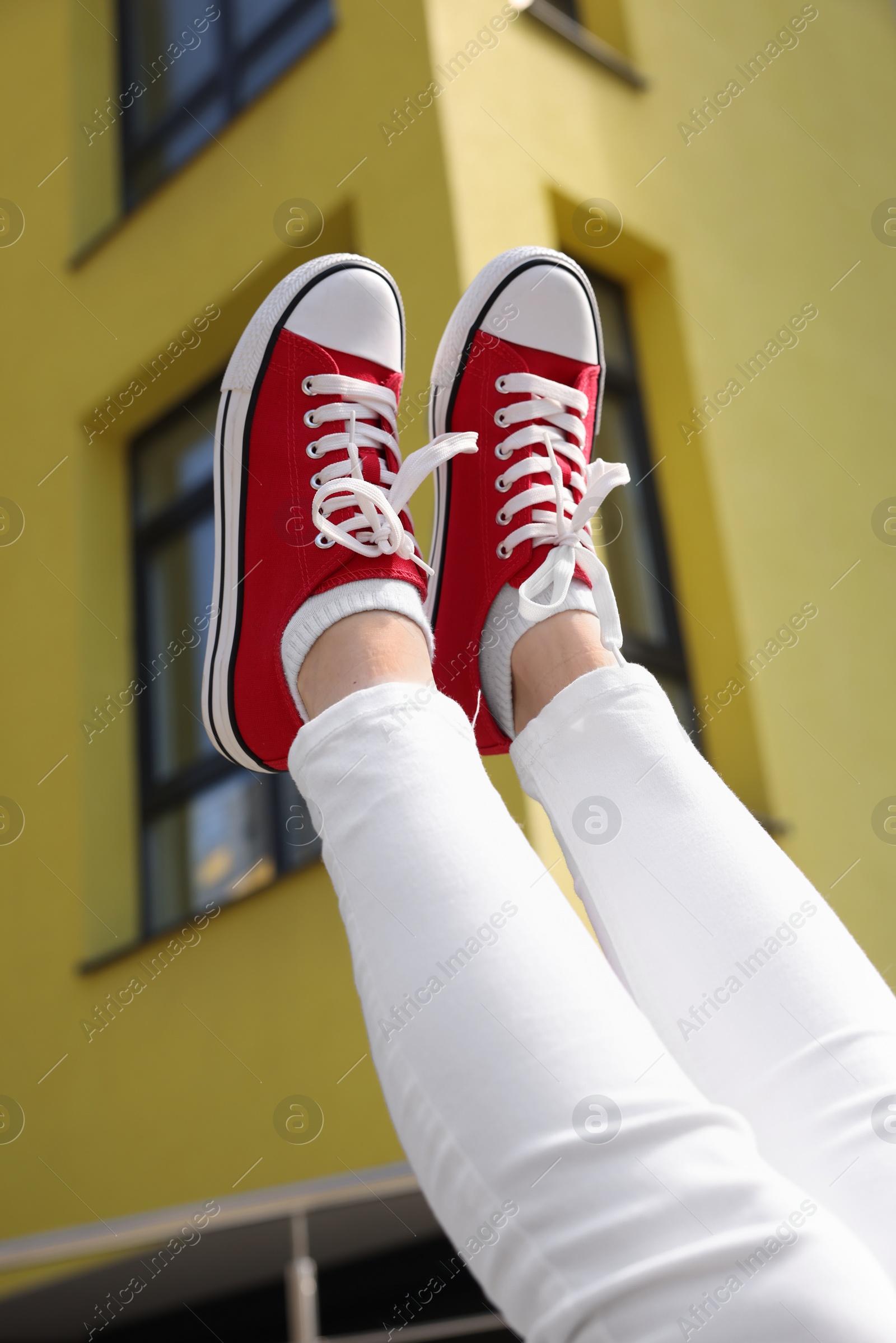 Photo of Woman wearing red classic old school sneakers outdoors, closeup
