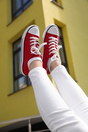 Photo of Woman wearing red classic old school sneakers outdoors, closeup