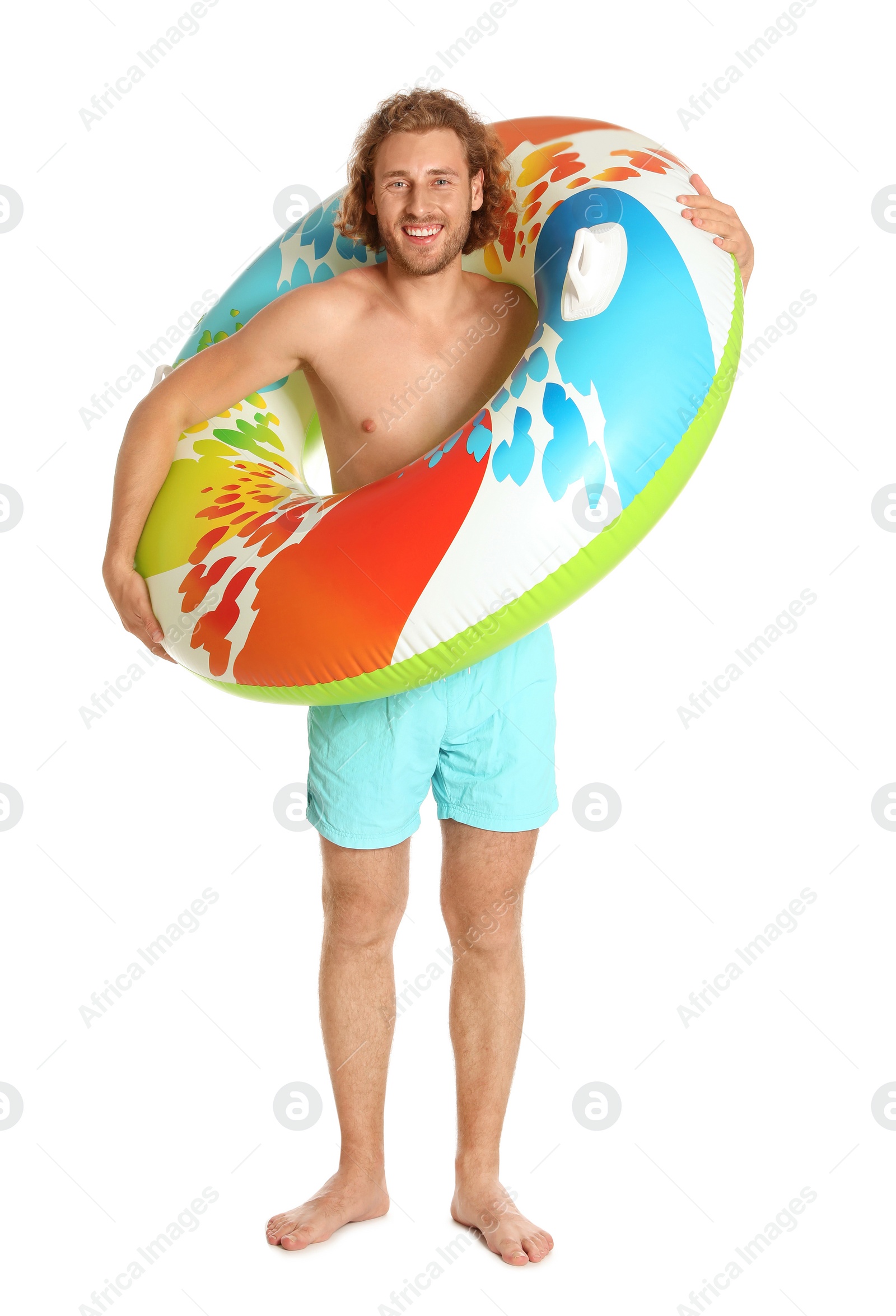 Photo of Attractive young man in swimwear with colorful inflatable ring on white background