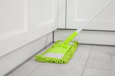 Cleaning of parquet floor with mop indoors