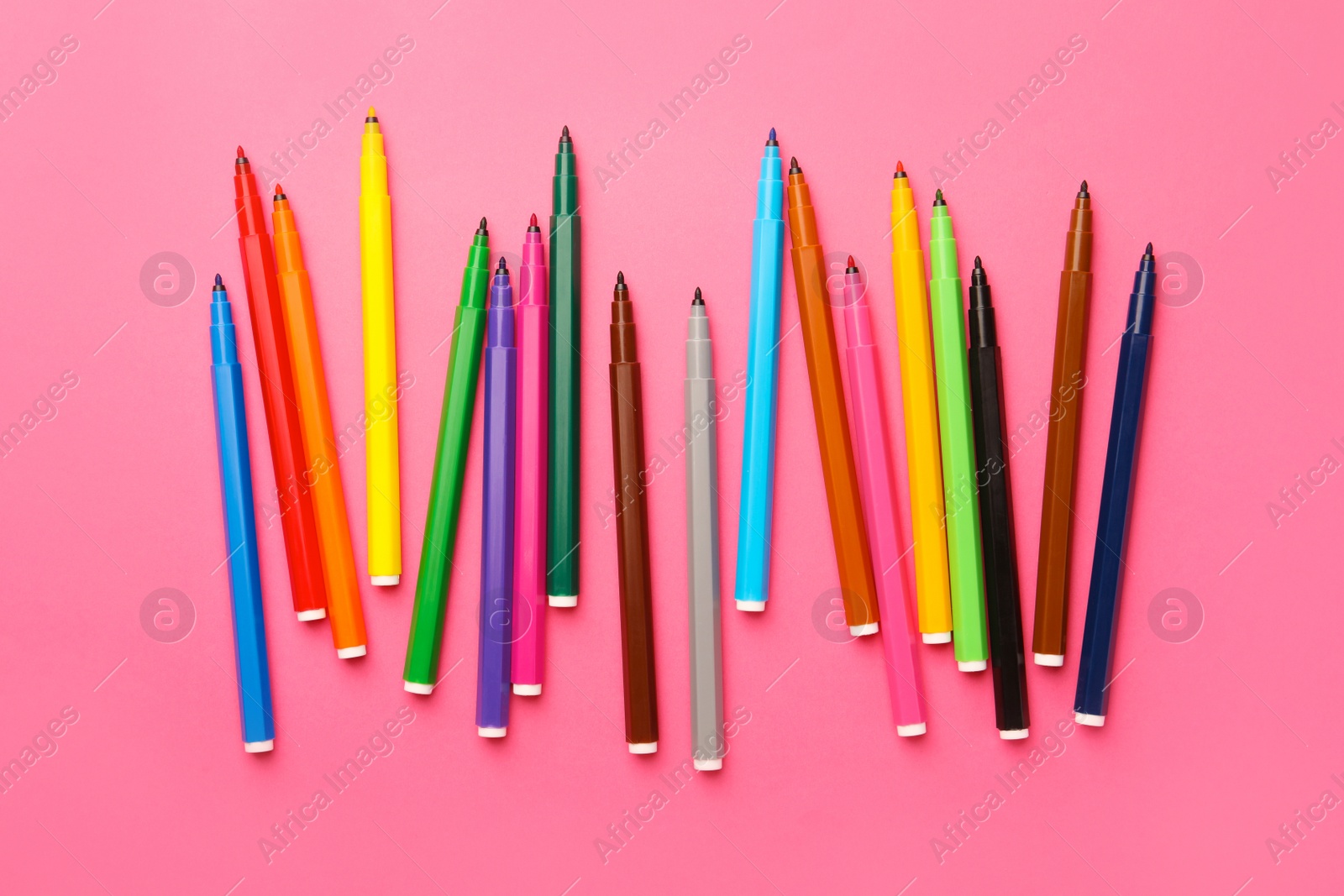 Photo of Many bright markers on pink background, flat lay