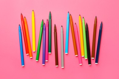 Photo of Many bright markers on pink background, flat lay