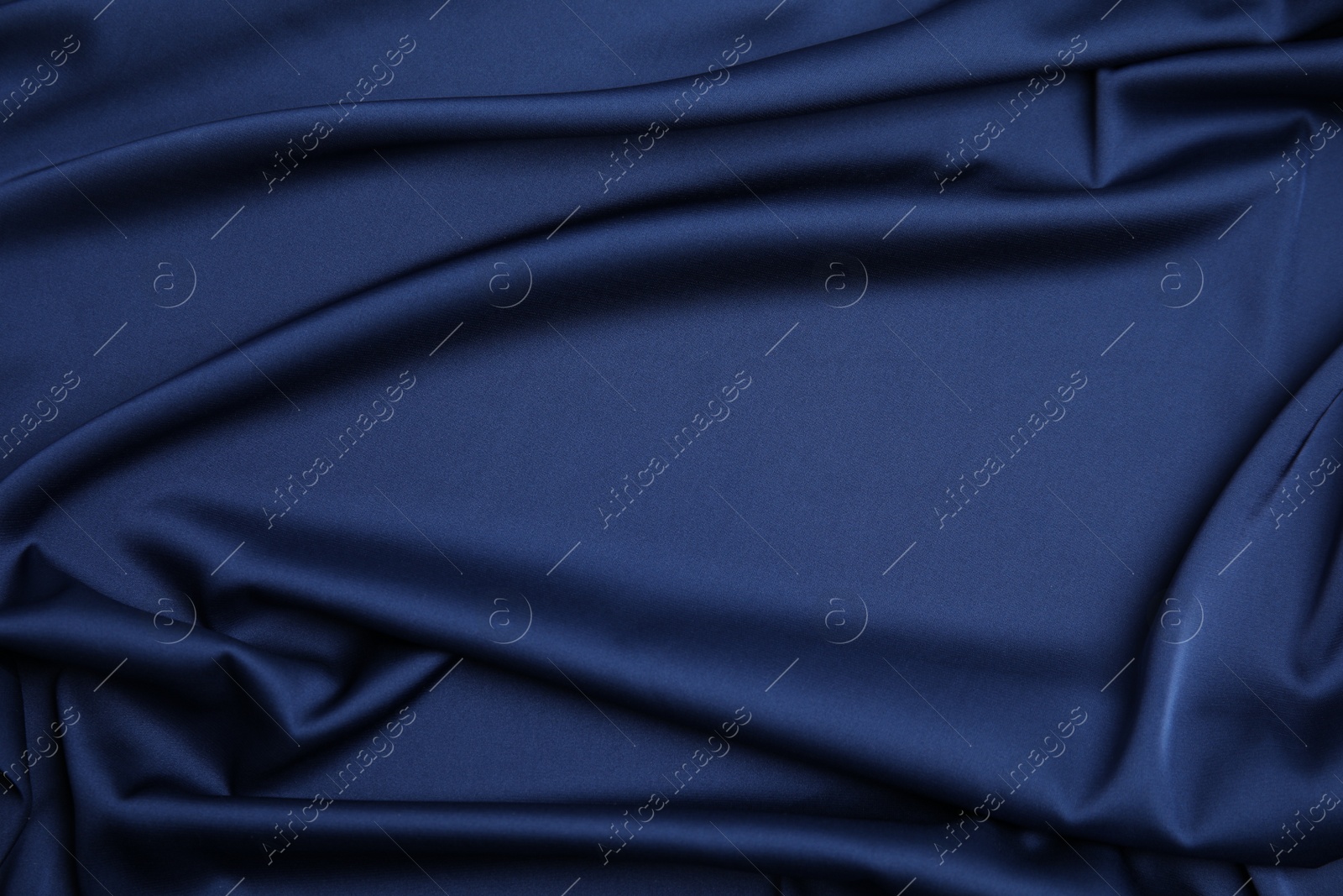 Photo of Crumpled dark blue silk fabric as background, top view