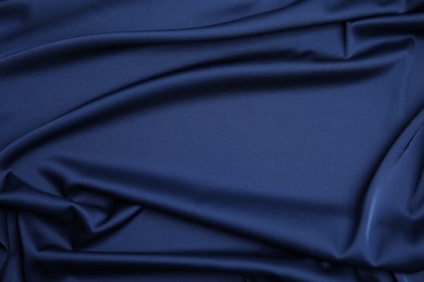 Photo of Crumpled dark blue silk fabric as background, top view