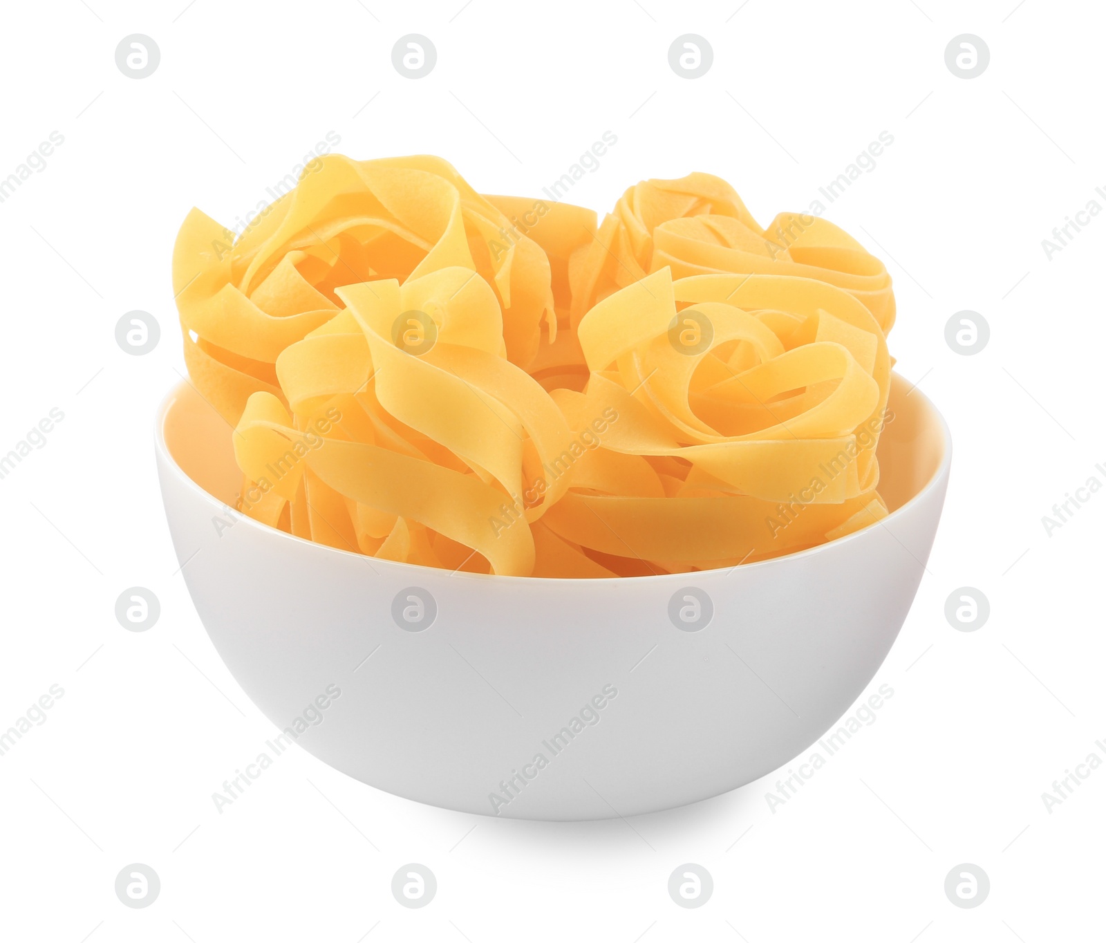Photo of Raw fettuccine pasta in bowl isolated on white